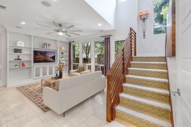 living room with built in shelves, light tile patterned flooring, and ceiling fan