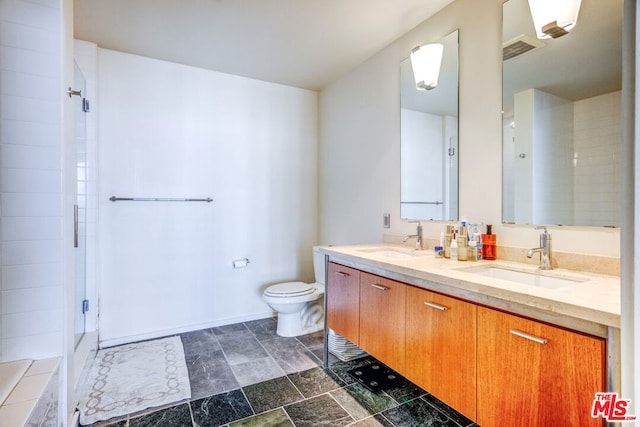 bathroom with tile patterned flooring, double vanity, walk in shower, and toilet