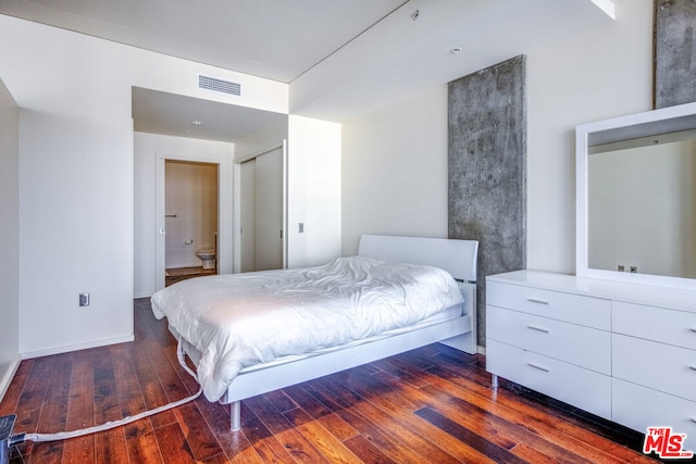 bedroom with hardwood / wood-style floors and ensuite bathroom