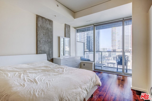 bedroom with dark wood-type flooring and access to outside