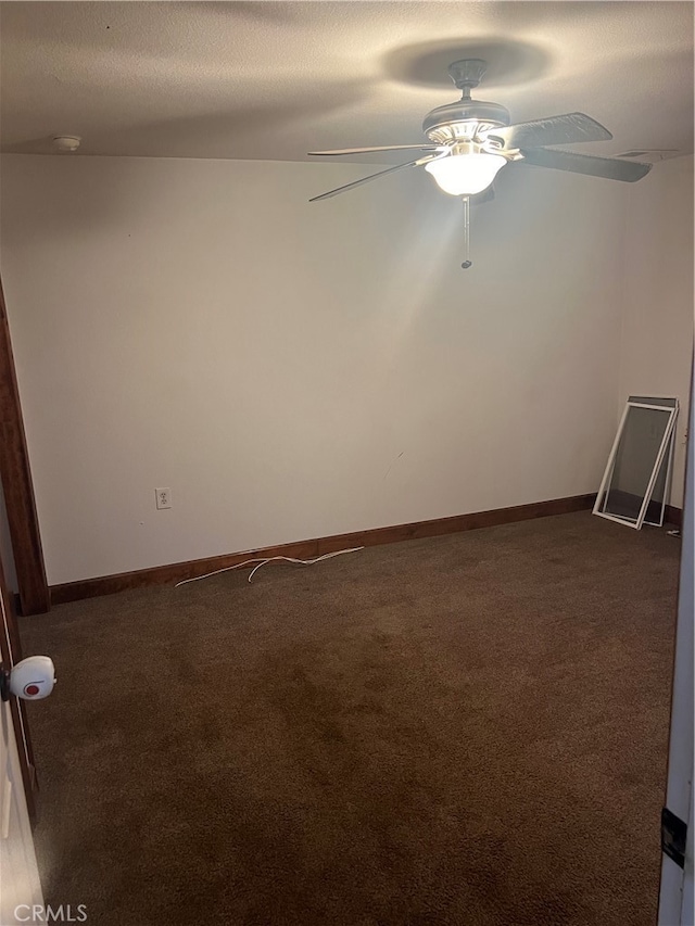 carpeted empty room with ceiling fan and a textured ceiling