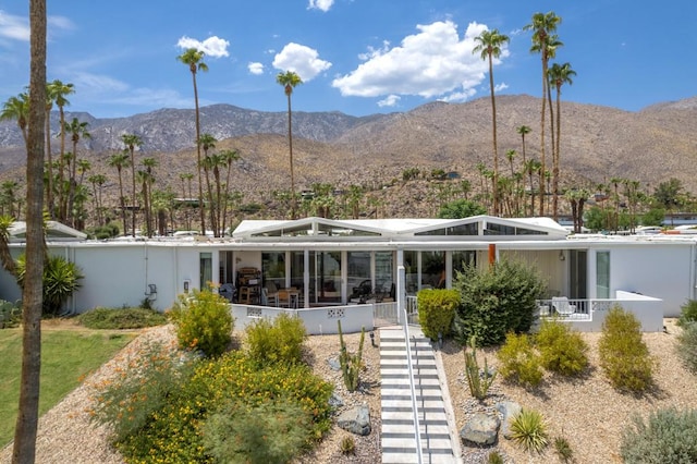 rear view of house featuring a sunroom and a mountain view