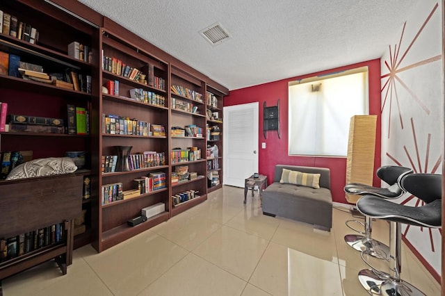 sitting room with light tile patterned flooring and a textured ceiling