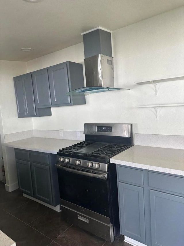 kitchen featuring dark tile patterned floors, gas stove, and extractor fan