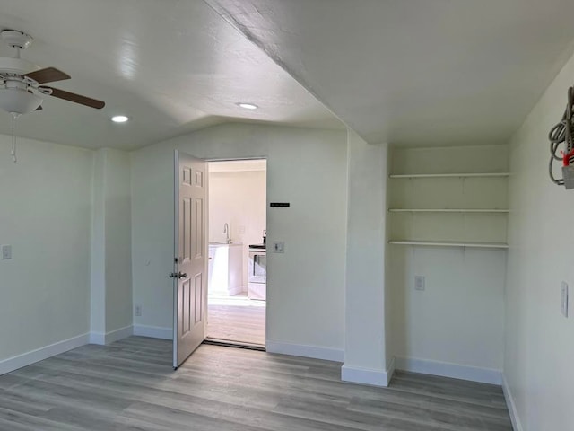 interior space with light hardwood / wood-style floors, vaulted ceiling, and ceiling fan