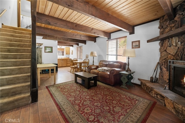 living room featuring a fireplace, beamed ceiling, wooden ceiling, and hardwood / wood-style flooring