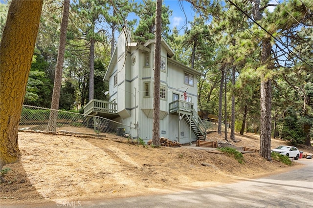 view of home's exterior with stairs, a chimney, and fence