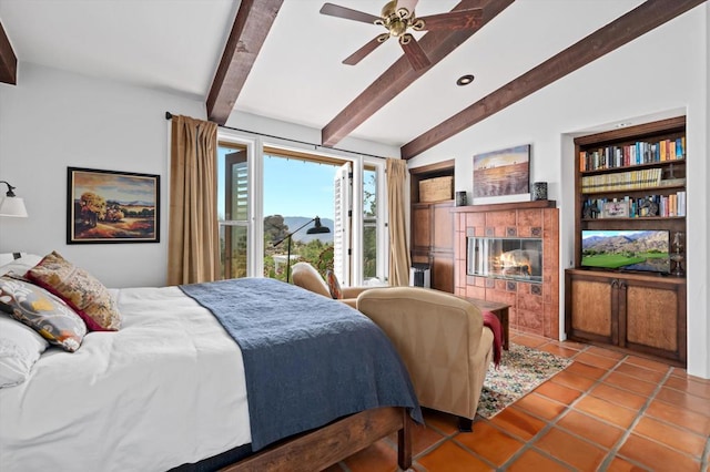 bedroom with tile patterned floors, vaulted ceiling with beams, a fireplace, and ceiling fan