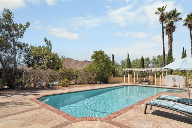 view of swimming pool with a mountain view, a pergola, and a patio area