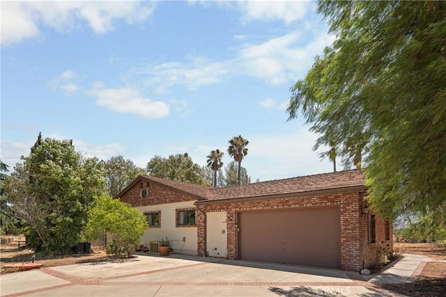 view of front facade with a garage and central AC