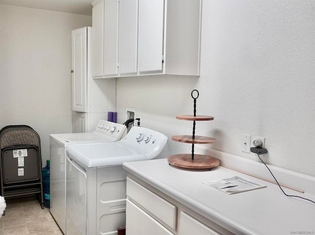 clothes washing area with washer and dryer, light tile patterned floors, and cabinets