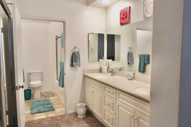 bathroom featuring vanity, tile patterned flooring, toilet, and walk in shower