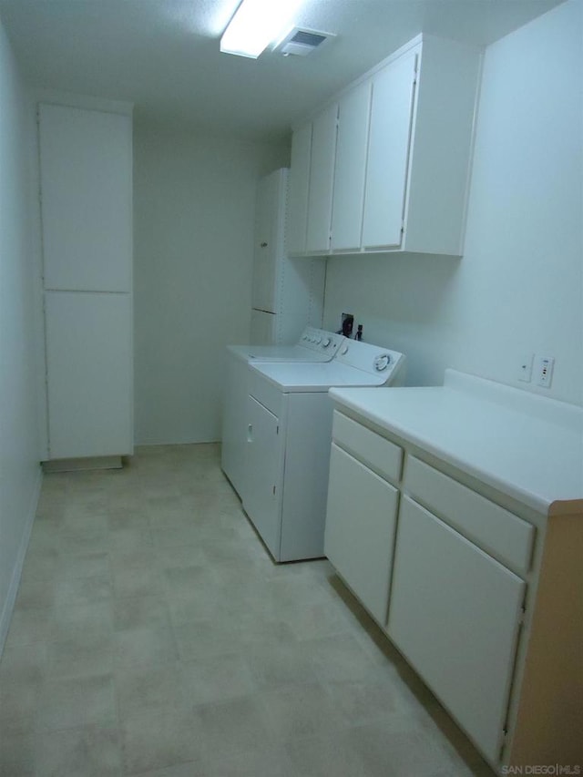 laundry area with cabinets and washing machine and clothes dryer