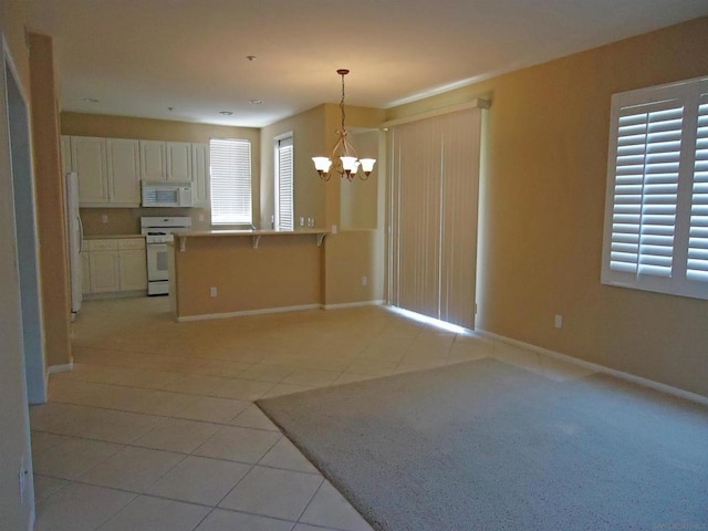 kitchen featuring white appliances, white cabinetry, decorative light fixtures, light tile patterned floors, and a chandelier