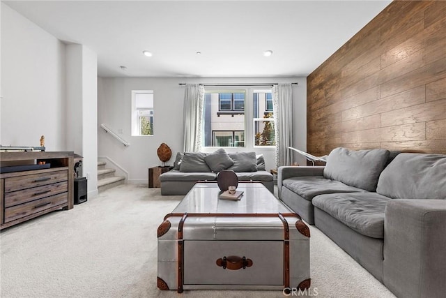 carpeted living room featuring wood walls and a healthy amount of sunlight