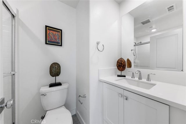 bathroom with vanity, toilet, and a shower with shower door