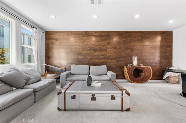 living room with light colored carpet and wood walls