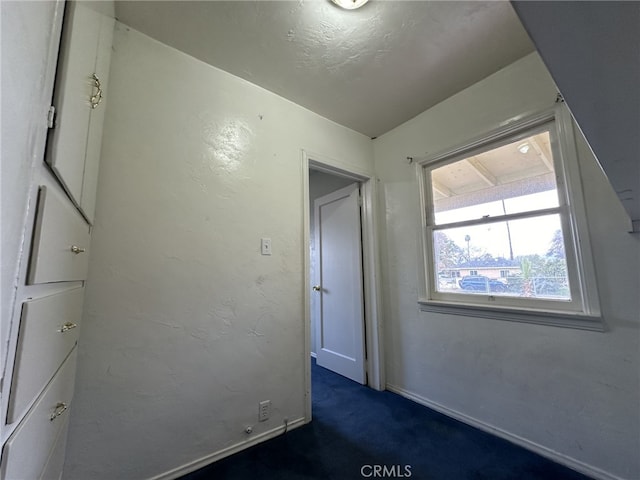 unfurnished bedroom with dark carpet