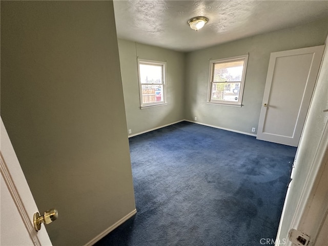 carpeted spare room featuring a textured ceiling