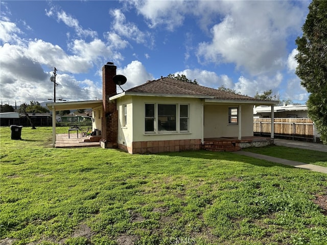 back of house with a patio and a lawn