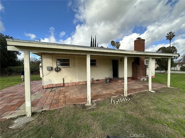 back of house with a patio area and a lawn