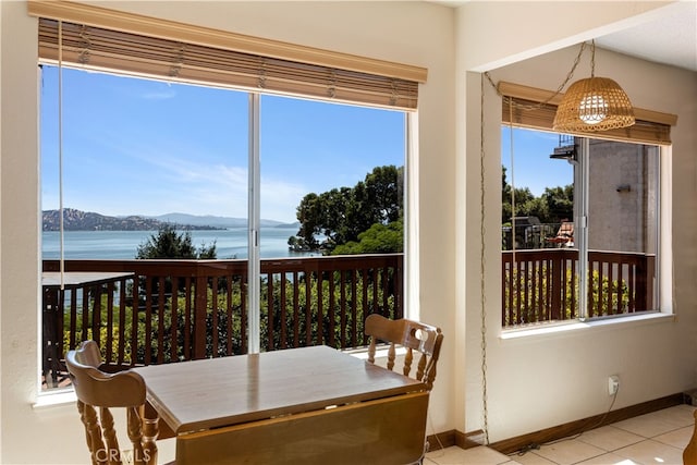 sunroom / solarium featuring a water and mountain view and a wealth of natural light