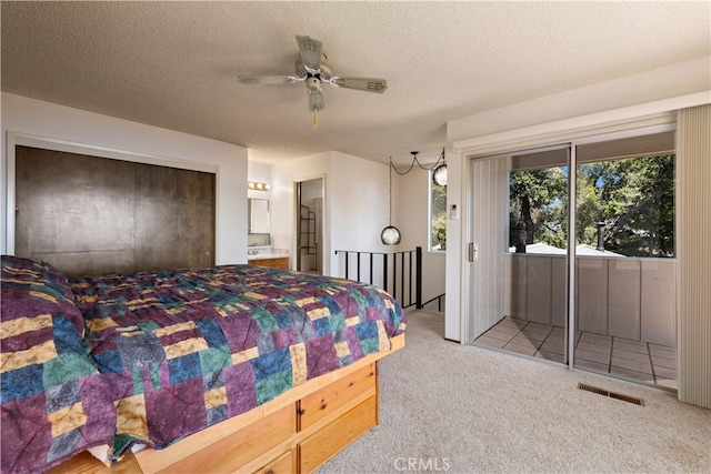 carpeted bedroom with a textured ceiling, connected bathroom, ceiling fan, and access to exterior