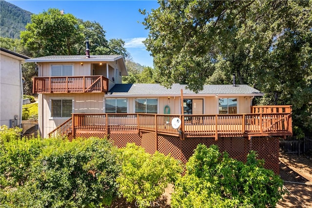 rear view of property featuring a deck with mountain view