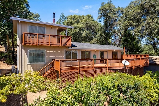 back of house featuring a balcony and a wooden deck