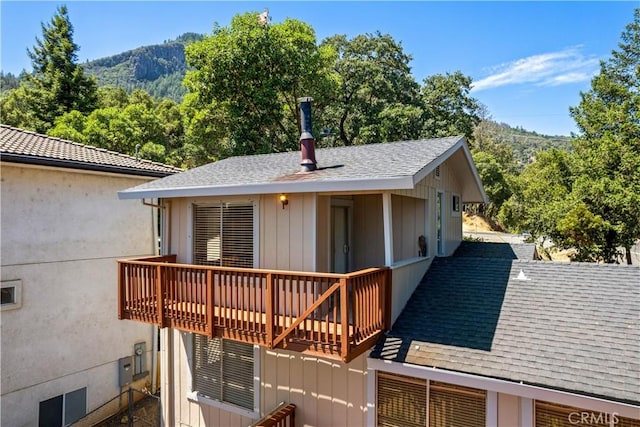 back of house featuring a shingled roof