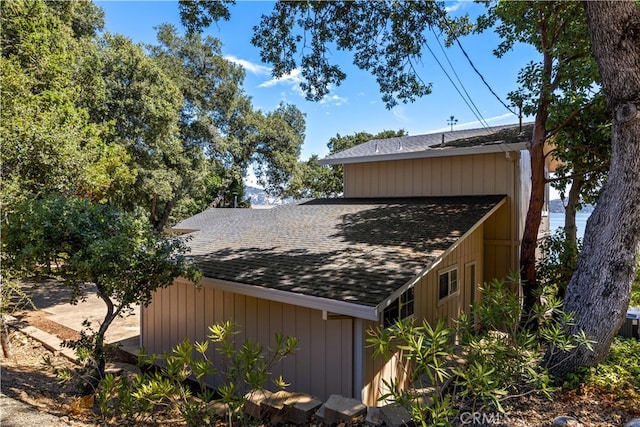 view of side of property featuring a shingled roof