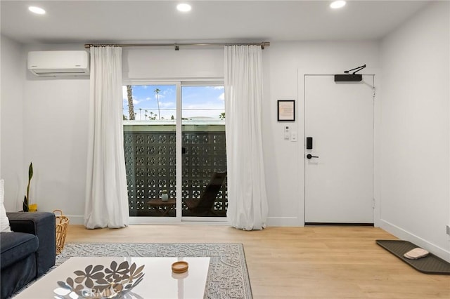 doorway with light hardwood / wood-style floors and a wall unit AC