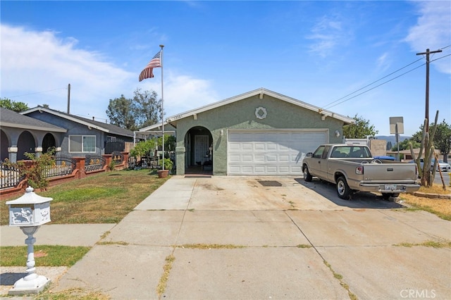 single story home featuring stucco siding, a garage, concrete driveway, and fence