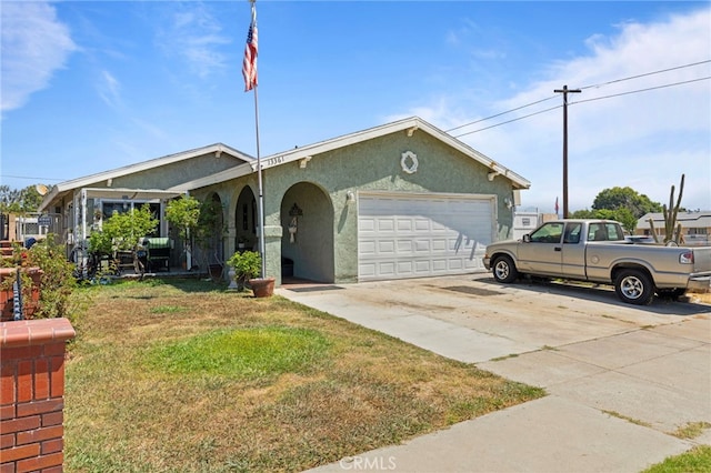 ranch-style house featuring an attached garage, driveway, a front yard, and stucco siding