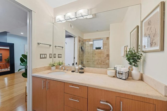 bathroom featuring vanity, tiled shower, and hardwood / wood-style flooring