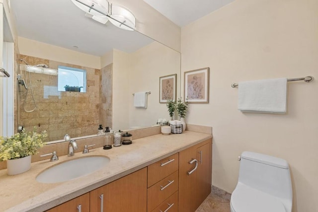 bathroom with toilet, vanity, tile patterned flooring, and tiled shower