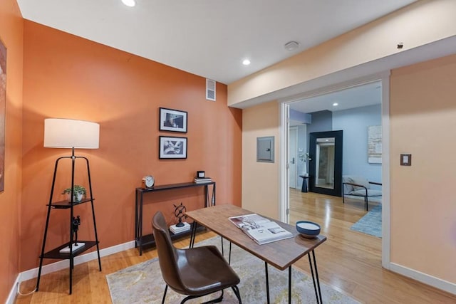 office area with electric panel and light hardwood / wood-style floors