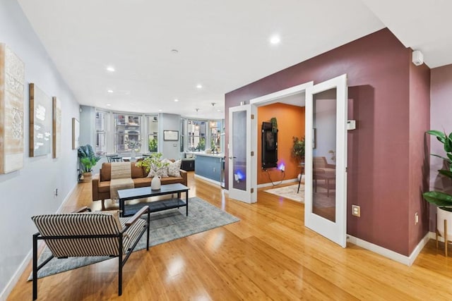 living room with light wood-type flooring and french doors