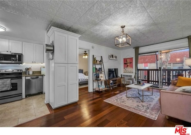 interior space featuring ceiling fan with notable chandelier and hardwood / wood-style floors