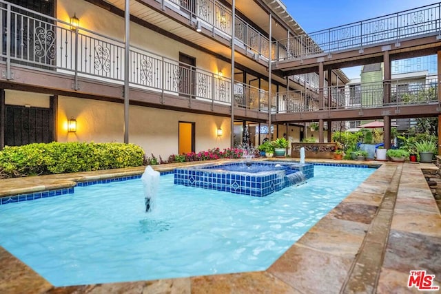 view of swimming pool with an in ground hot tub and pool water feature