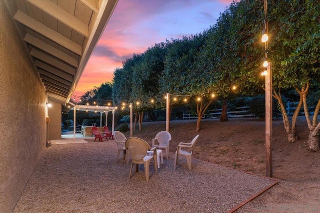 yard at dusk featuring a patio