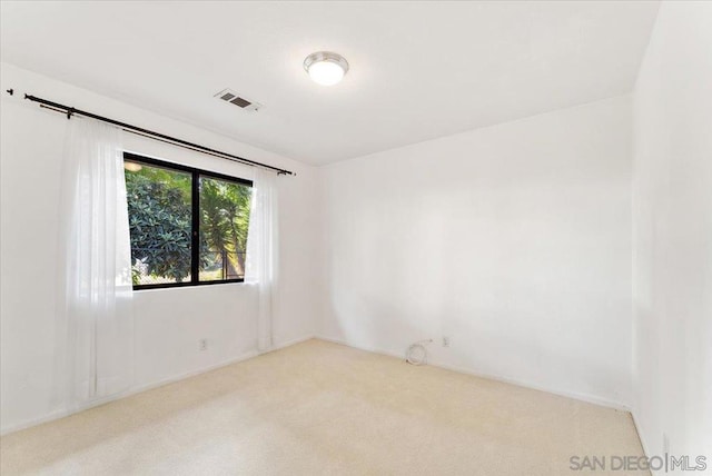 unfurnished room featuring light carpet