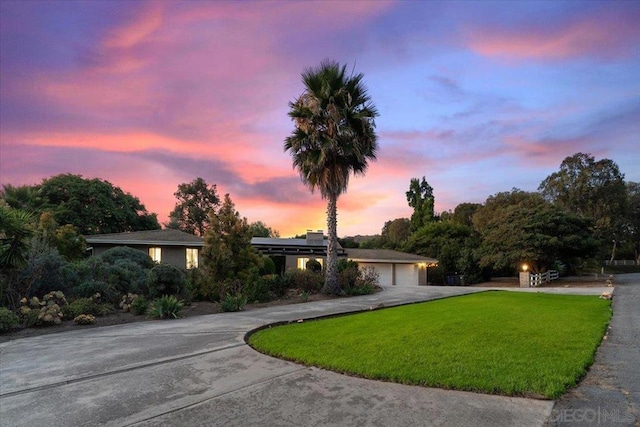 ranch-style house with a yard and a garage