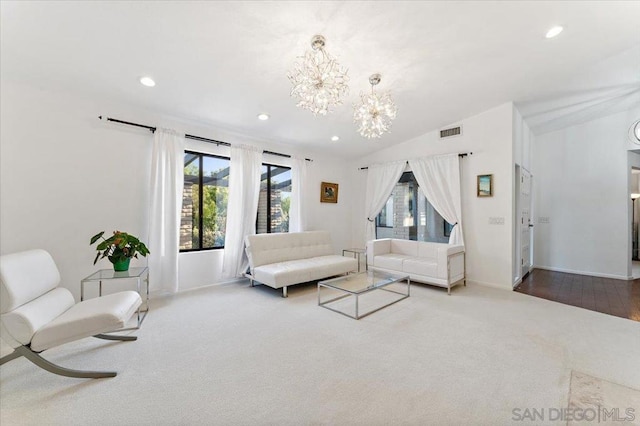 living room featuring an inviting chandelier, lofted ceiling, and hardwood / wood-style floors