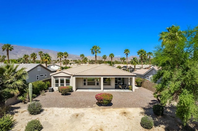 back of property featuring a mountain view and a patio