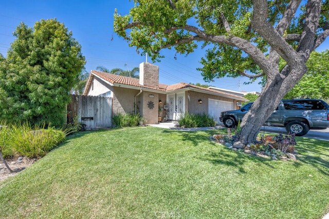 ranch-style home featuring a garage and a front yard