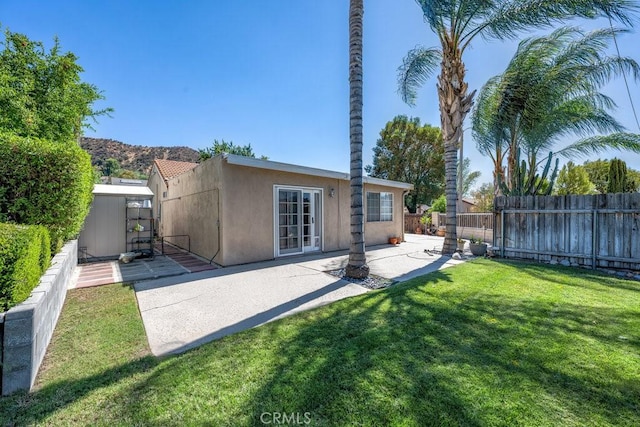 rear view of house featuring a patio area and a lawn