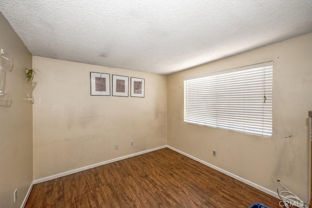 spare room featuring hardwood / wood-style floors and a textured ceiling