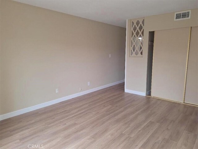 unfurnished bedroom featuring light hardwood / wood-style floors and a closet