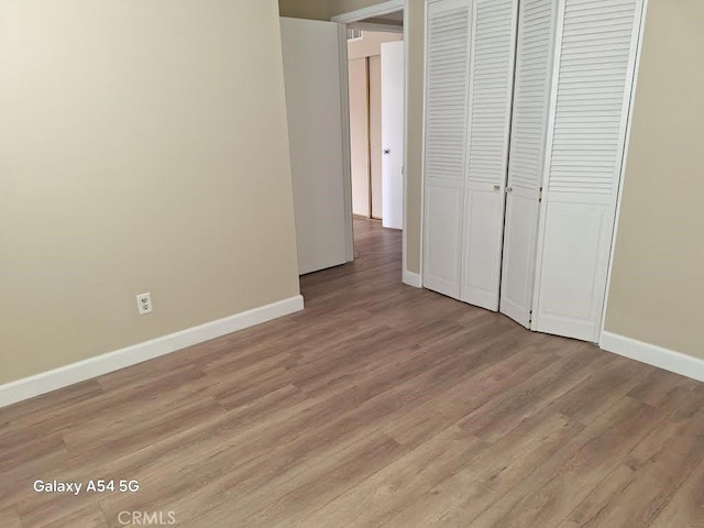 unfurnished bedroom with light hardwood / wood-style flooring and a closet